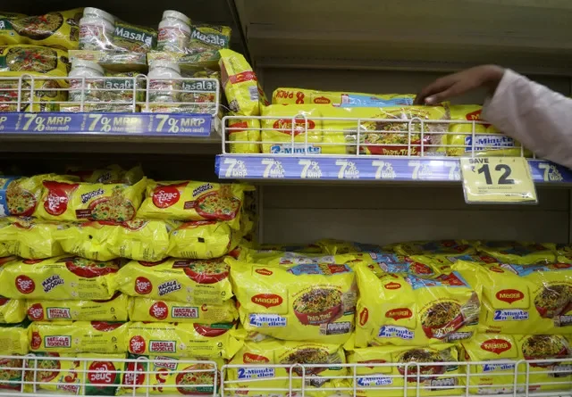 FOTO DE ARQUIVO: Um funcionário organiza pacotes de macarrão Maggi da Nestlé ao lado do macarrão Snac tac da Reliance em uma prateleira de um supermercado da Reliance em Mumbai, Índia, 16 de março de 2021. REUTERS/Niharika Kulkarni/File Photo