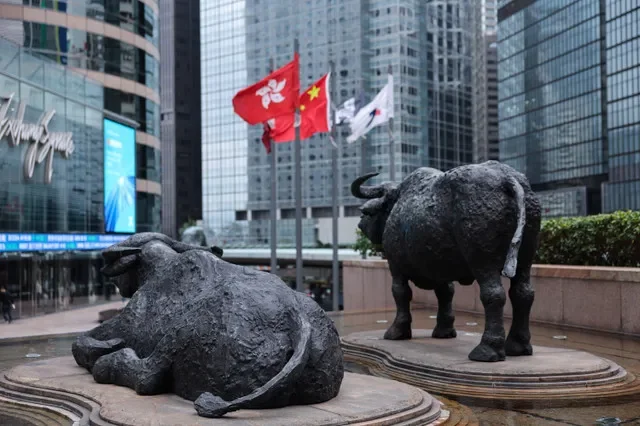 Bull statues stand in front of electronic displays showing the Hang Seng Index at Exchange Square in Hong Kong, China. REUTERS/Tyrone Siu