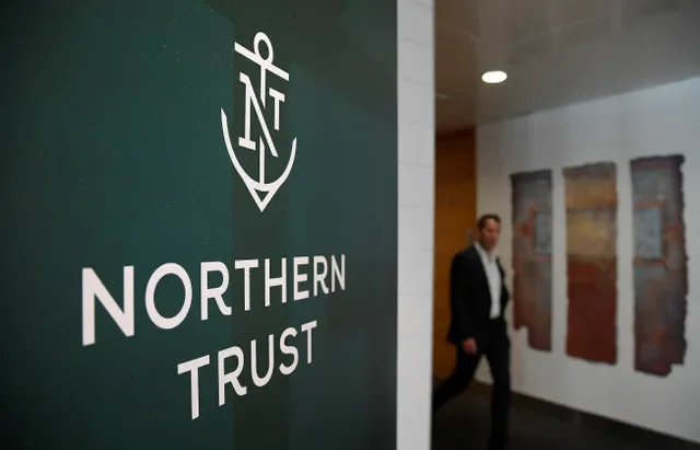 An employee walks past the company logo at Northern Trust offices in London, Britain, on August 1, 2019, in a photo taken by Toby Melville for Reuters.