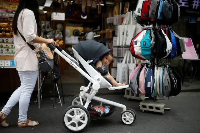 FOTO DE ARQUIVO: Uma mulher empurra seu bebê em um carrinho enquanto faz compras na área de Hongdae, em Seul, Coreia do Sul. REUTERS/Kim Hong-Ji/File Photo