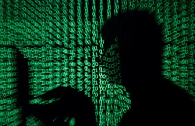 Un hombre sostiene una computadora portátil mientras se proyecta código cibernético sobre él en esta imagen de ilustración. REUTERS/Kacper Pempel/Illustration/File Photo