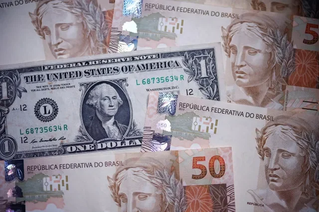 أوراق نقدية من الريال البرازيلي والدولار الأمريكي في رسم توضيحي التقط في 18 ديسمبر 2024. رويترز/أماندا بيروبيلي