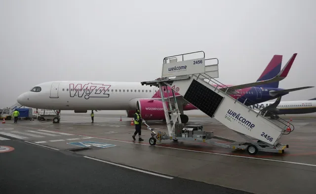 A ground crew member maneuvers boarding stairs toward a Wizz Air Airbus A321neo jet on the tarmac at Warsaw-Modlin Airport in Poland. REUTERS/Kacper Pempel