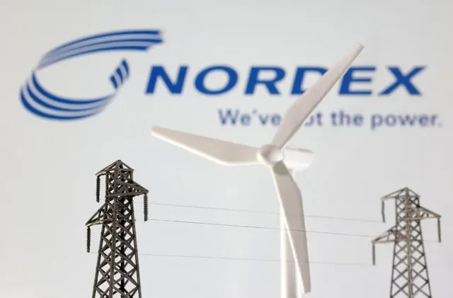A visual representation featuring miniature wind turbines and utility poles positioned before the Nordex corporate branding, captured in early 2023. REUTERS/Dado Ruvic/Illustration