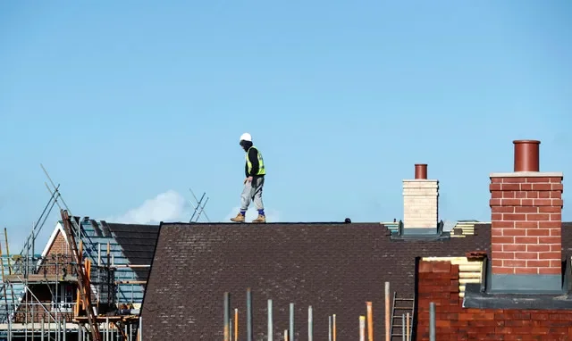 Un trabajador de la construcción camina sobre un tejado en una urbanización de Taylor Wimpey en Aylesbury, Reino Unido, el 7 de febrero de 2017. REUTERS/Eddie Keogh/Foto de archivo