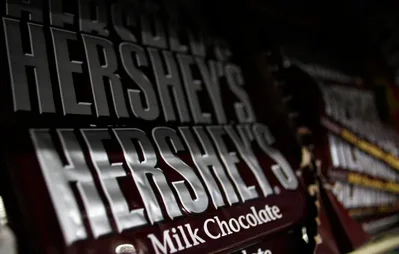 Confectionery giants like Hershey are restoring cocoa content to their products following a sharp decline in bean prices from 2024 records. This shift away from chocolate alternatives is expected to lower retail prices and drive a recovery in global demand for cocoa farmers.