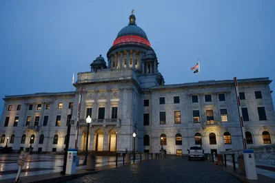 Os legisladores de Rhode Island avaliam um imposto de 8,99 por cento sobre milionários e um orçamento estadual de 14,9 mil milhões de dólares no final da sessão de 2026. As medidas incluem o alargamento de prazos de prescrição para vítimas de abuso e novas regras na habitação e saúde.