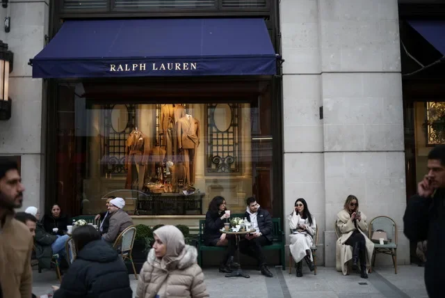 2023年3月11日,人們坐在英國倫敦新邦德街的 Ralph Lauren 門店外。路透社/Henry Nicholls/ 檔案照片