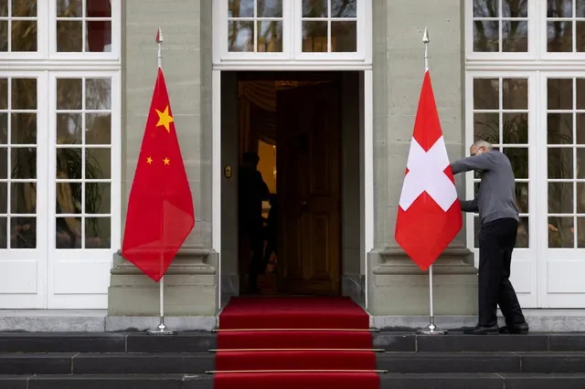 FOTO DE ARCHIVO: Un miembro del personal prepara las banderas antes de la llegada de la presidenta suiza, Viola Amherd, y el primer ministro de la República Popular China, Li Qiang, en Kehrsatz, cerca de Berna, Suiza, el 15 de enero de 2024. PETER KLAUNZER/Pool via REUTERS/File Photo
