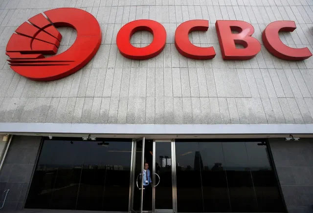 Un hombre está de pie en una puerta cerca de un logotipo de Oversea-Chinese Banking Corp (OCBC) en su oficina central en Singapur el 11 de febrero de 2015. REUTERS/Edgar Su