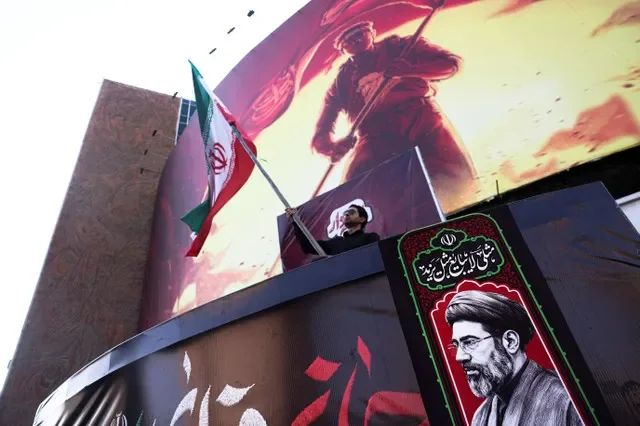 Un hombre sostiene una bandera iraní, junto a un retrato del líder supremo de Irán, Mojtaba Khamenei, en Teherán, Irán, el 13 de agosto de 2026. Majid Asgaripour/WANA (Agencia de Noticias de Asia Occidental) vía REUTERS