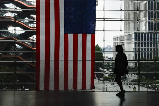A shopper walks past a U.S. flag at Hudson Yards in New York City, U.S., July 27, 2026.