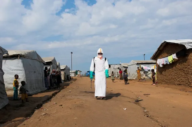 FILE PHOTO: Displaced people watch a health worker in full personal protective equipment (PPE) preparing to disinfect the area during the burial of suspected Ebola victims at the Kigonze displaced persons camp in Bunia, eastern Democratic Republic of Congo, on June 18, 2026, one month after the outbreak was declared.