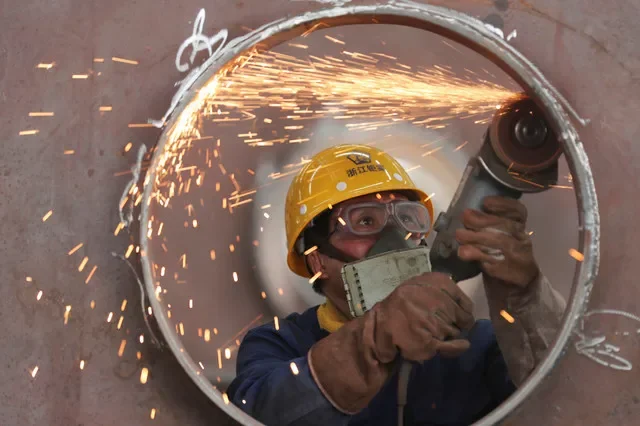 Um funcionário trabalha em uma linha de produção fabricando estruturas de aço em uma fábrica em Huzhou, província de Zhejiang, China, em 17 de maio de 2020. China Daily via REUTERS