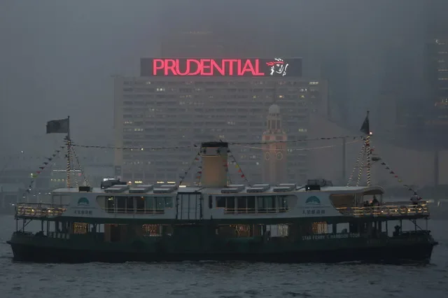 FILE PHOTO: A ferry sails past an advertisement of Prudential Assurance under foggy weather at the Victoria Harbour in Hong Kong, China March 9, 2016. REUTERS/Bobby Yip//File Photo