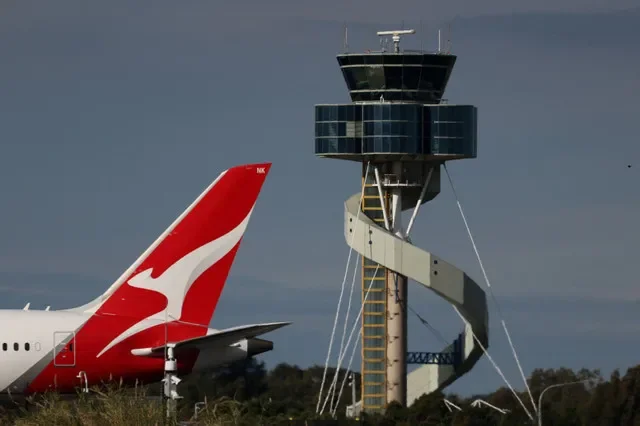 FILE PHOTO: A Qantas plane passes an air traffic control tower as it taxis along a runway Sydney Airport, in Sydney, Australia, August 21, 2026. REUTERS/Hollie Adams/File Photo