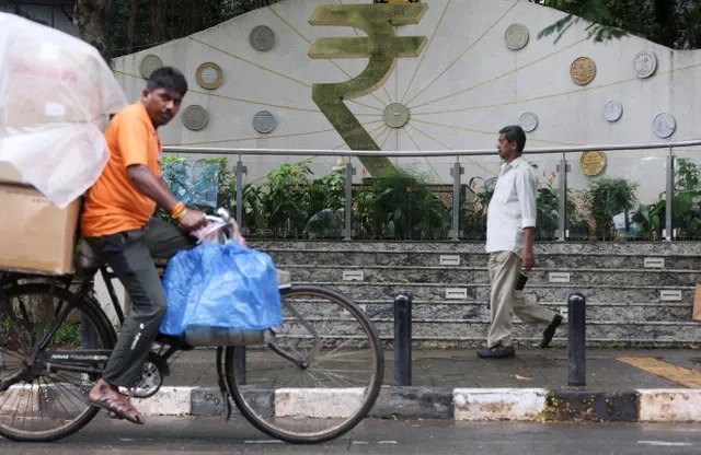 FILE PHOTO: People move past the Indian Rupee symbol sculpture outside the Reserve Bank of India (RBI) headquarters in Mumbai, India, August 5, 2026. REUTERS/Francis Mascarenhas/File Photo