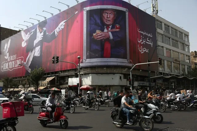 Người dân lái xe gần tấm biển quảng cáo in hình Tổng thống Mỹ Donald Trump trên một tòa nhà ở Tehran, Iran, ngày 31 tháng 8 năm 2026. Majid Asgaripour/WANA (Hãng thông tấn Tây Á) qua REUTERS