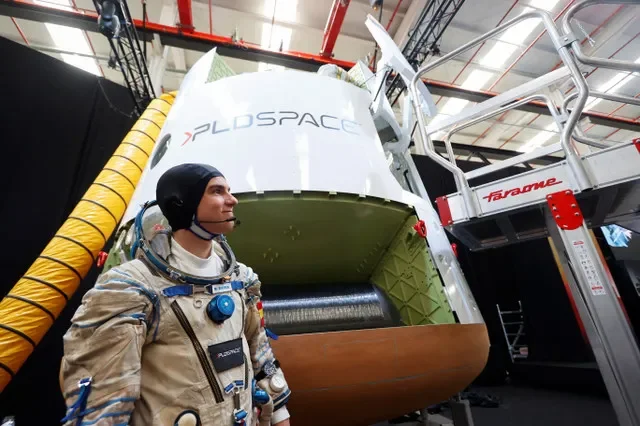 A person dressed as an astronaut stands next to the manned capsule Lince on the day of PLD Space's company event "Beyond_" at its headquarters in Elche, Spain, October 7, 2024. REUTERS/Eva Manez