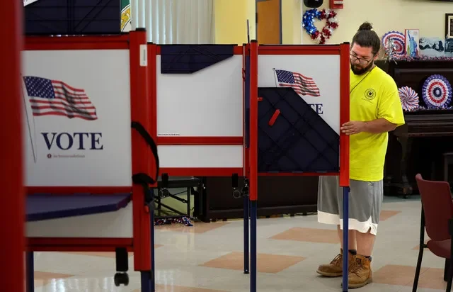 City employee Rich Mayne helps set up polls at the Worcester Senior Center on Monday, Aug. 31.