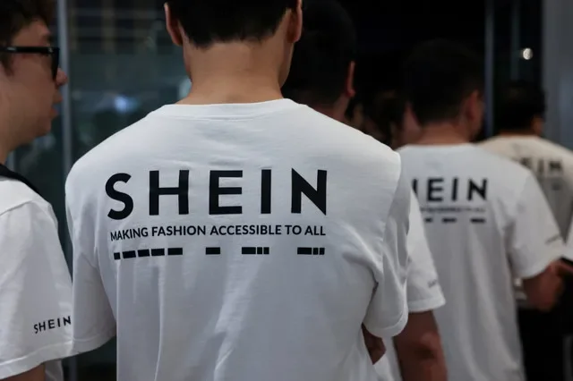 พนักงานสวมเสื้อยืดที่มีโลโก้ของผู้ค้าปลีกแฟชั่นออนไลน์ Shein ระหว่างพิธีเข้าจดทะเบียนในตลาดหลักทรัพย์ฮ่องกง ในฮ่องกง ประเทศจีน เมื่อวันที่ 1 กันยายน 2026 REUTERS/ไทโรน ซิว