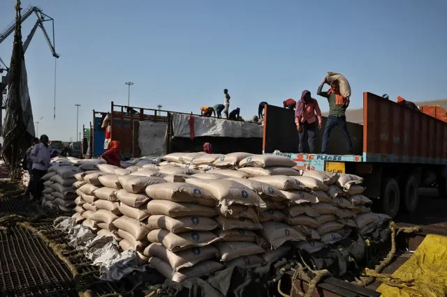 FOTO DE ARQUIVO: Trabalhadores descarregam sacos de açúcar de caminhões e os colocam em uma rede para carregamento em um navio cargueiro no porto de Deendayal em Kandla, no estado ocidental de Guzerate, Índia, 5 de abril de 2025. REUTERS/Amit Dave/Foto de arquivo