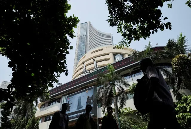 صورة أرشيفية: أشخاص يمرون أمام شاشة تعرض نتائج التداول خارج بورصة بومباي (BSE) في مومباي، الهند، 7 أبريل 2025. رويترز/Francis Mascarenhas