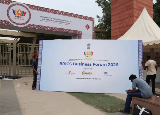 Pessoas transportam uma placa do Fórum Empresarial BRICS 2026 para ser instalada do lado de fora do Bharat Mandapam, local da 18ª Cúpula do BRICS em Nova Délhi, Índia, em 11 de setembro de 2026. REUTERS/Sahiba Chawdhary