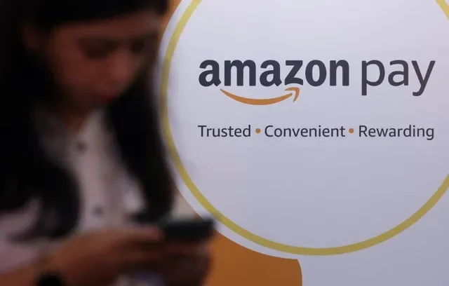 หญิงคนหนึ่งกำลังใช้โทรศัพท์ข้างโลโก้ Amazon Pay ระหว่างงาน Global Fintech Fest ในมุมไบ ประเทศอินเดีย วันที่ 20 กันยายน 2022 REUTERS/ฟรานซิส มาสคาเรนฮาส