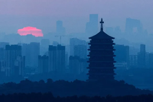 O Pagode Yongding ergue-se contra o sol nascente e o horizonte de Pequim, com os arranha-céus do Distrito Central de Negócios, incluindo a sede da CCTV, visíveis ao longe, em Pequim, China, em 3 de setembro de 2026. REUTERS/Maxim Shemetov