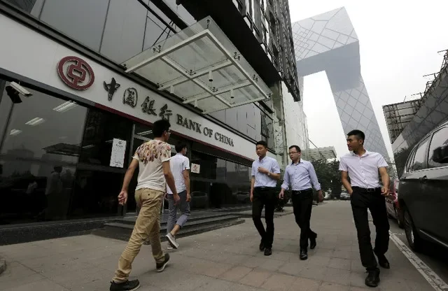 FILE PHOTO: Pedestrians walk past a branch of Bank of China in Beijing, June 25, 2015. REUTERS/Jason Lee/File Photo