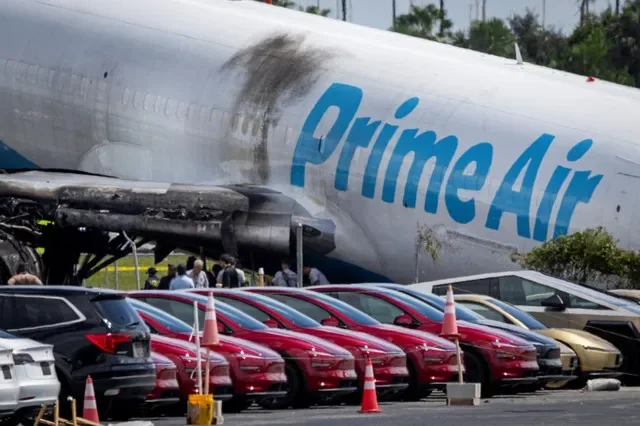 Tesla cars are parked in a lot next to where a crashed Amazon Prime Air cargo plane came to rest, where airport officials said it overran a runway at Miami International Airport, in Miami, Florida, United States, September 7, 2026. REUTERS/Marco Bello