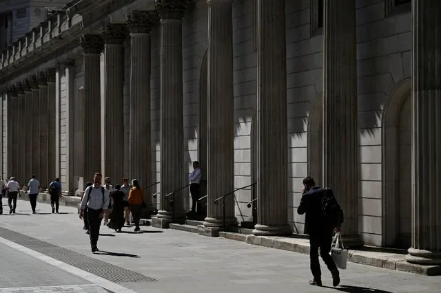 FILE PHOTO: People walk by the Bank of England building in London, Britain, July 27, 2026. REUTERS/Chris J. Ratcliffe/File Photo