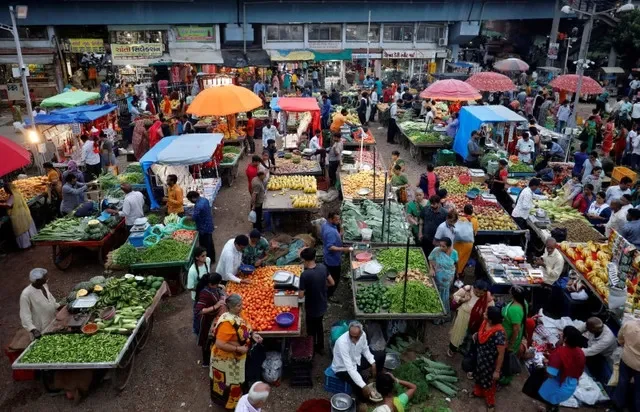 Customers buy fruits and vegetables at an open air evening market in Ahmedabad, India, August 21, 2023. REUTERS/Amit Dave