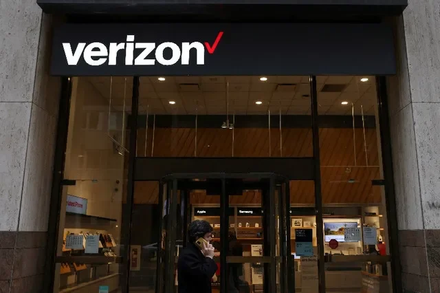 FOTO DE ARCHIVO: Una persona camina junto a una tienda de Verizon en Manhattan, Ciudad de Nueva York, EE. UU., el 22 de noviembre de 2021. REUTERS/Andrew Kelly/Foto de archivo