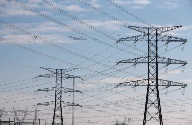 An Iberia jet flies over power lines outside Madrid, December 23, 2013. REUTERS/Paul Hanna
