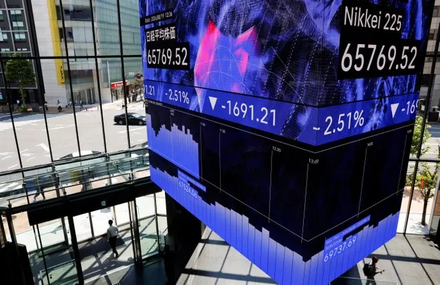 ผู้คนเดินอยู่ใต้หน้าจอดิจิทัลแสดงค่าเฉลี่ยดัชนีนิกเคอิของญี่ปุ่น ณ ศูนย์การประชุมในกรุงโตเกียว ประเทศญี่ปุ่น วันที่ 19 สิงหาคม 2026 REUTERS/Manami Yamada/ภาพแฟ้ม
