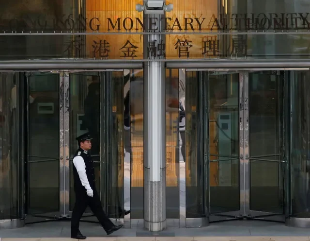 An attendant walks outside the entrance to Hong Kong Monetary Authority in Hong Kong, China November 10, 2015. Picture taken November 10, 2015. REUTERS/Bobby Yip