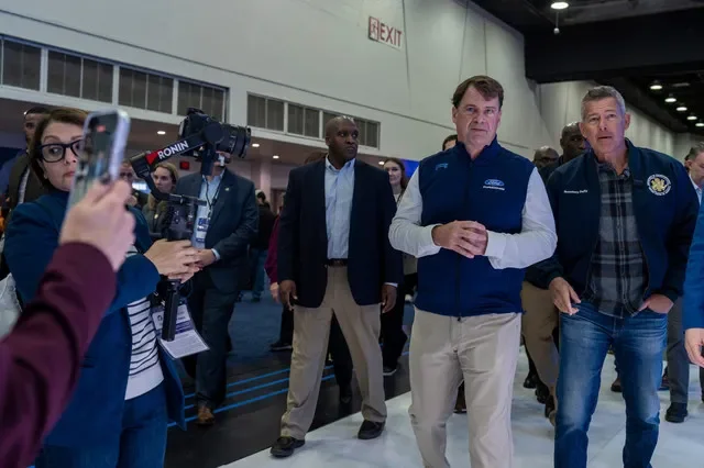 Jim Farley, left, president and CEO of Ford Motor Co., walks with Sean Duffy, U.S. secretary of transportation, during the 2026 Detroit Auto Show at Huntington Place in Detroit on Saturday, Jan. 17, 2026.