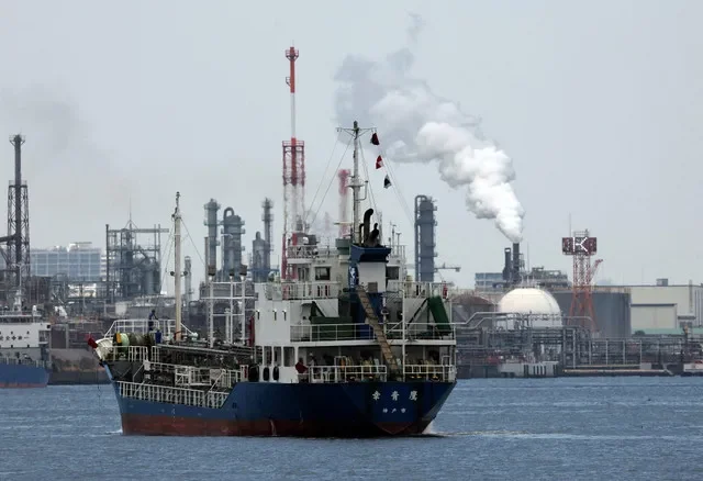 FILE PHOTO: A small tanker sails near an oil refinery, in the Keihin Industrial Zone in Kawasaki, south of Tokyo, Japan March 17, 2026. REUTERS/Issei Kato/File Photo