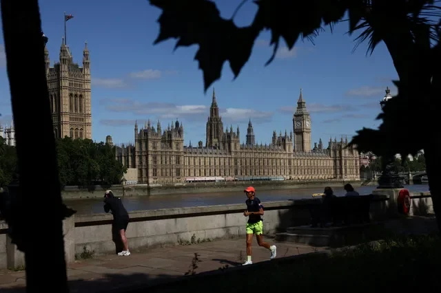 A jogger runs along the bank of the River Thames opposite the Houses of Parliament and the Elizabeth Tower, commonly known as Big Ben, in London, Britain, June 29, 2026. REUTERS/Jack Taylor