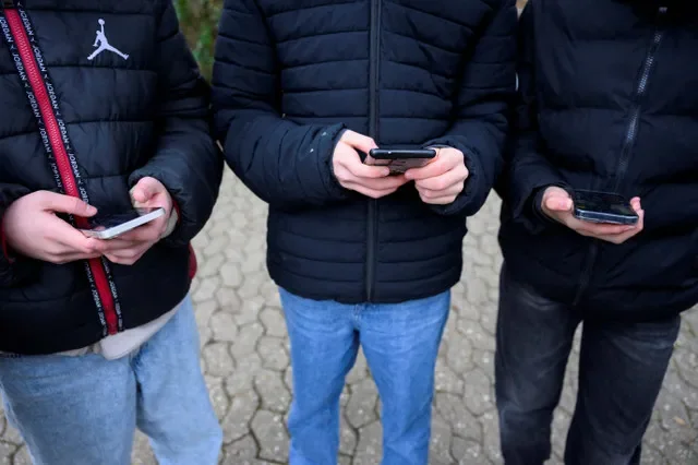 資料写真:2026年2月20日、ドイツ・ボンでスマートフォンを見ながらポーズをとる若者たち。ロイター/Jana Rodenbusch/資料写真