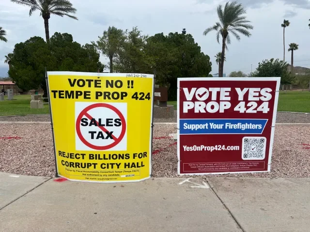 Two signs, one opposing Prop 424 and another supporting the measure, stand at the corner of Mill Avenue and Curry Road in north Tempe on Sept. 16, 2026.