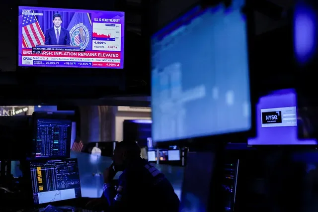 FILE PHOTO: A trader works, as screens broadcast a press conference by U.S. Federal Reserve Chair Kevin Warsh following the Fed rate announcement, on the floor of the New York Stock Exchange (NYSE) in New York City, U.S., September 16, 2026. REUTERS/Jeenah Moon/ File Photo