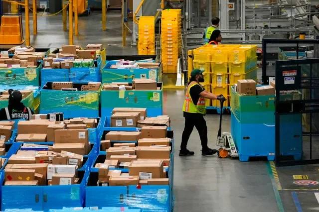 Workers move products during Cyber Monday at Amazon's fulfilment center in Robbinsville, New Jersey, U.S., December 1, 2025. REUTERS/Eduardo Munoz