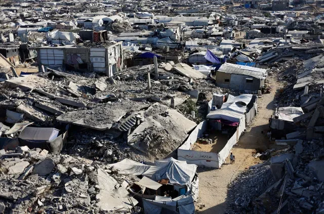 Trẻ em Palestine đi qua đống đổ nát của các tòa nhà dân cư bị phá hủy trong chiến tranh tại trại tị nạn Jabalia ở phía bắc Dải Gaza, ngày 5 tháng 8 năm 2026. REUTERS/Mahmoud Issa