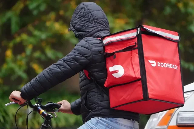 ภาพถ่ายแฟ้มภาพ: พนักงานส่งอาหารของ DoorDash ขี่จักรยานท่ามกลางสายฝนในย่านแมนฮัตตัน นครนิวยอร์ก รัฐนิวยอร์ก สหรัฐอเมริกา วันที่ 13 พฤศจิกายน 2020 สำนักข่าว REUTERS/คาร์โล อัลเลกรี/ภาพถ่ายแฟ้มภาพ