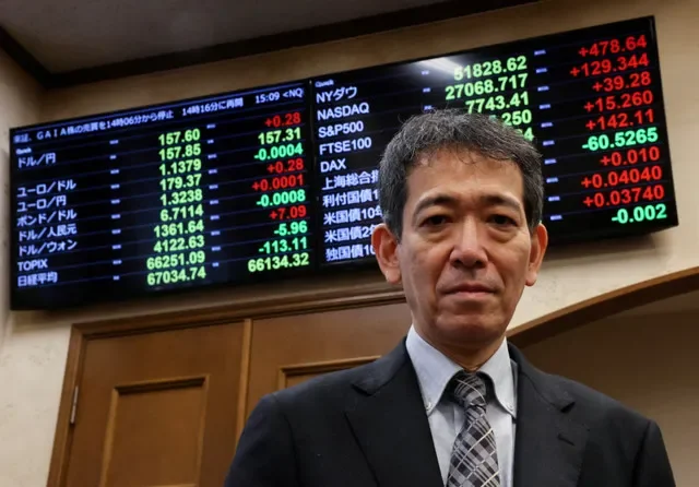 2026年9月28日,日本財務省財務官三村淳在東京接受路透社專訪後,於顯示日圓對美元匯率、其他貨幣匯率及股票指數的電子看板前留影。路透社/金京勳