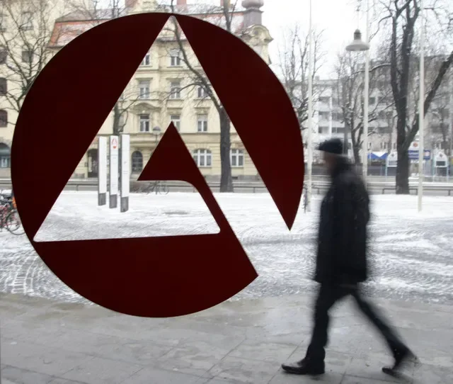 A man walks behind the labour office sign of an unemployment center in Munich January 29, 2009. REUTERS/Michaela Rehle