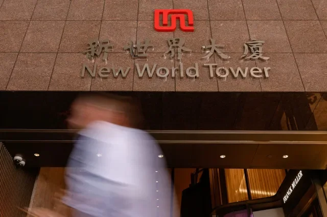 一名男子走過位於中國香港新世界大廈的新世界發展總部。2024年9月27日。路透社/蕭文超